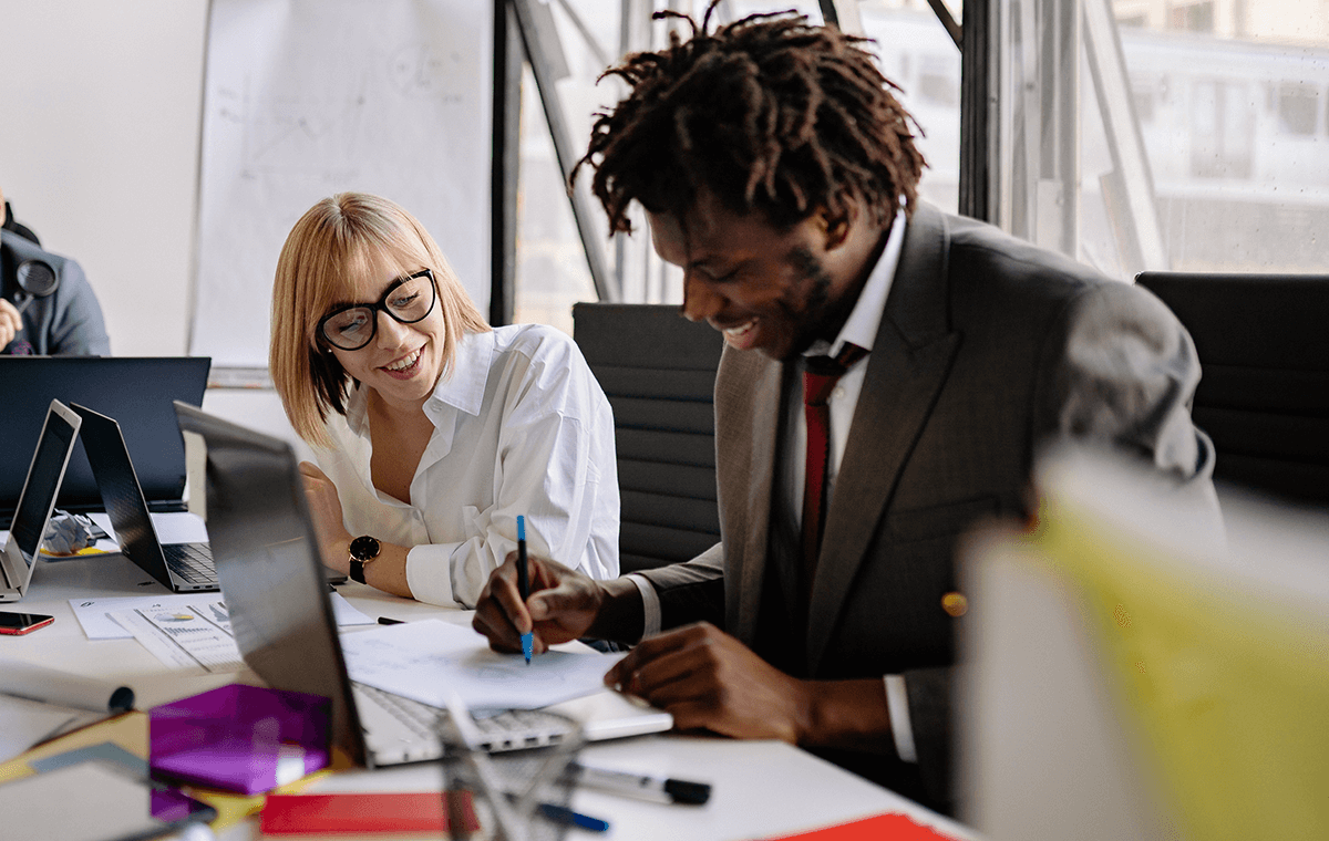 man demonstrating to female coworker in reverse mentoring session at the office