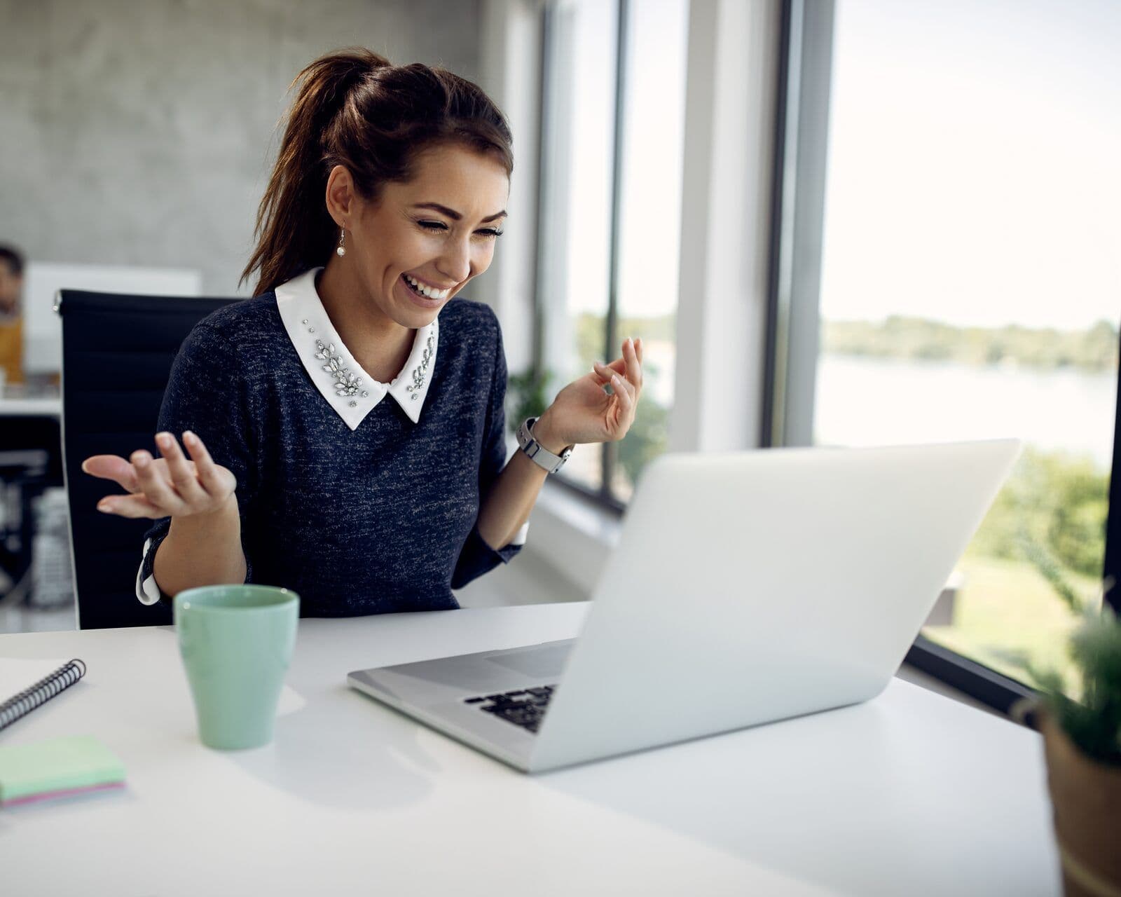 A woman talks and gestures to her laptop as she rehearses a conversation