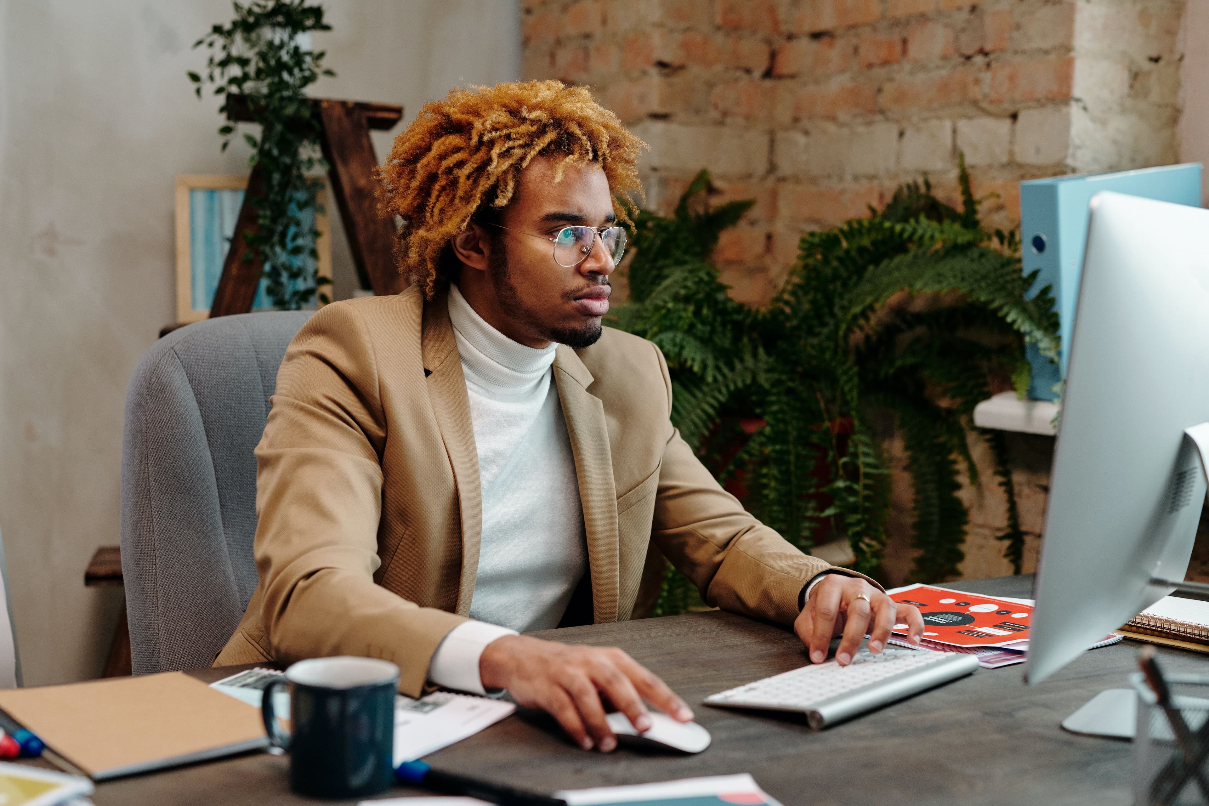 male employee sitting at desktop computer planning career advancement